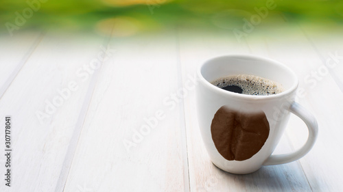 concept coffee brean print pattern on cup on white wood table. photo