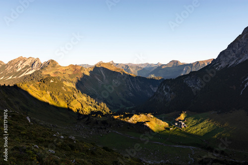 Mountain pasture Klesenza at sunrise. Alpine landscape with mountains,meadows, forest and strong contrast under blu sky. Vorarlberg, Austria