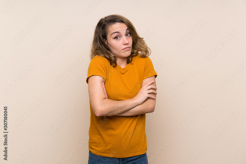 Young blonde girl over isolated background making doubts gesture while lifting the shoulders Young blonde girl over isolated background making doubts gesture while lifting the shoulders