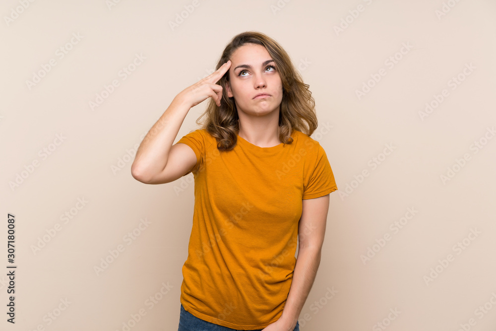 Young blonde girl over isolated background with problems making suicide gesture Young blonde girl over isolated background with problems making suicide gesture