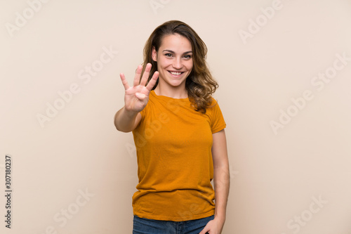 Young blonde girl over isolated background happy and counting four with fingers