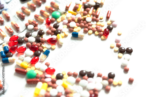 colorful pills and drugs scattered on white background with copy space