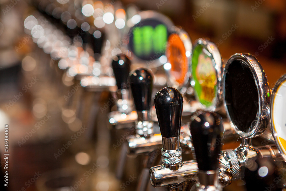 Row of Beer Taps in Bar for different types of drink. Bar interior Row of Beer Taps in Bar for different types of drink. Bar interior