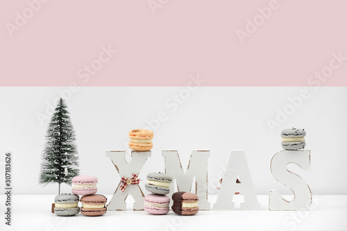 rench dessert macaroons or macarons on Christmas white and pink background with inscription xmas. food recipe concept. copy space. photo