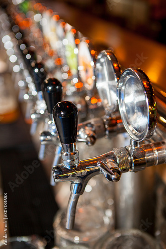 Fototapeta Naklejka Na Ścianę i Meble -  Row of Beer Taps in Bar for different types of drink. Bar interior