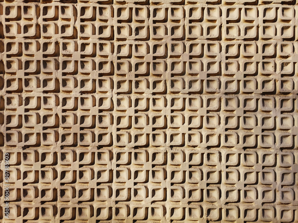Simple geometric stucco work on an exterior wall. Light beige plaster. Architectural detail. Symmetric pattern Simple geometric stucco work on an exterior wall. Light beige plaster. Architectural detail. Symmetric pattern