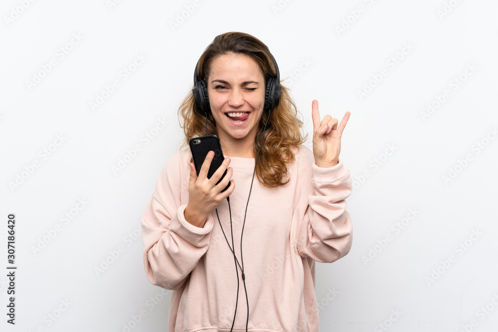 Young blonde woman using the mobile with headphones and singing Young blonde woman using the mobile with headphones and singing