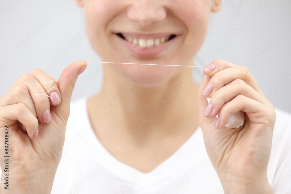 Dental hygiene and care. Dental floss. Young healthy woman face with beauty smile. Beautiful girl. Person healthcare. Female in the morning in bathroom. Dental hygiene and care. Dental floss. Young healthy woman face with beauty smile. Beautiful girl. Person healthcare. Female in the morning in bathroom.