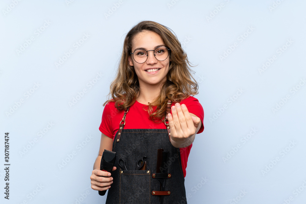 Young blonde woman with hairdresser or barber dress and holding hair cutting machine Young blonde woman with hairdresser or barber dress and holding hair cutting machine