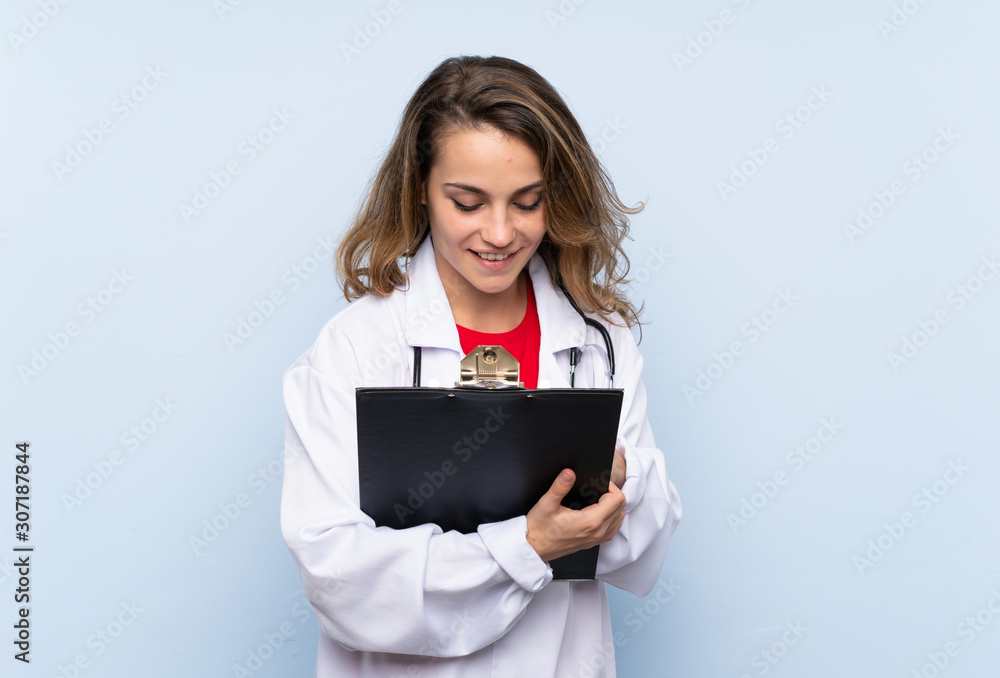 Young blonde woman with doctor gown and writing in a folder Young blonde woman with doctor gown and writing in a folder