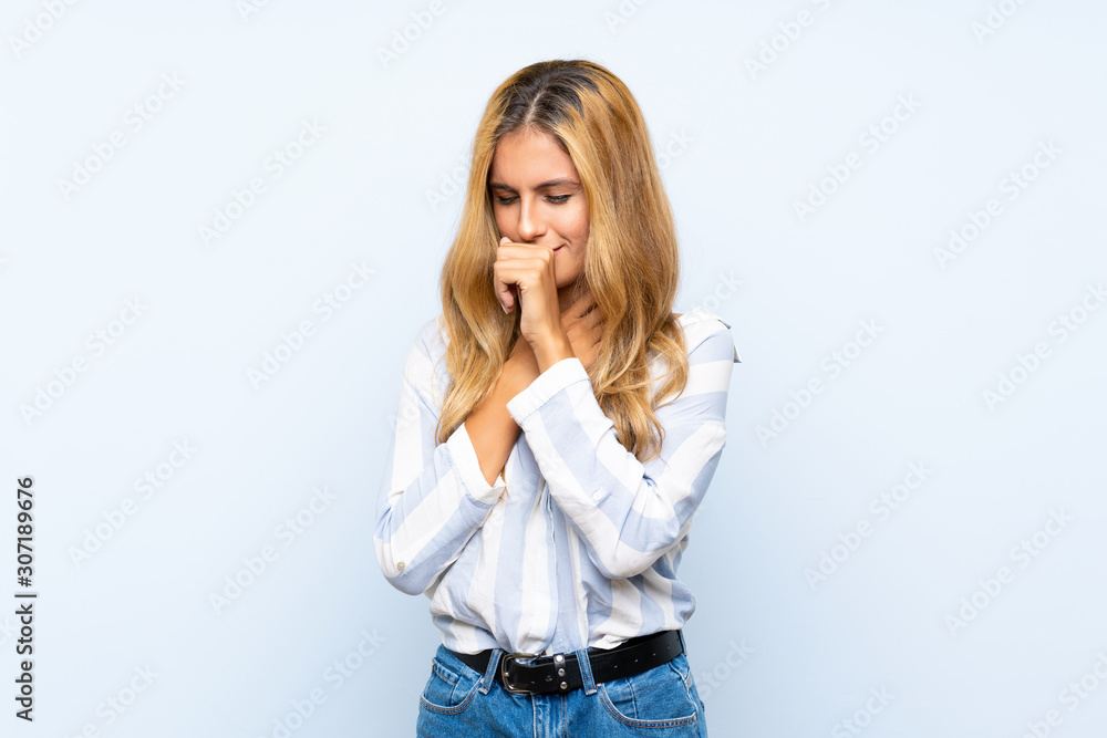 Young blonde woman over isolated blue background is suffering with cough and feeling bad Young blonde woman over isolated blue background is suffering with cough and feeling bad