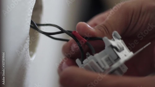 Electrician connecting the wires of disassembled light switch