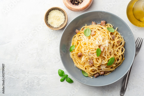 Classic spaghetti pasta carbonara with pancetta, egg yolk and parmesan cheese on concrete background. Top view, copy space.