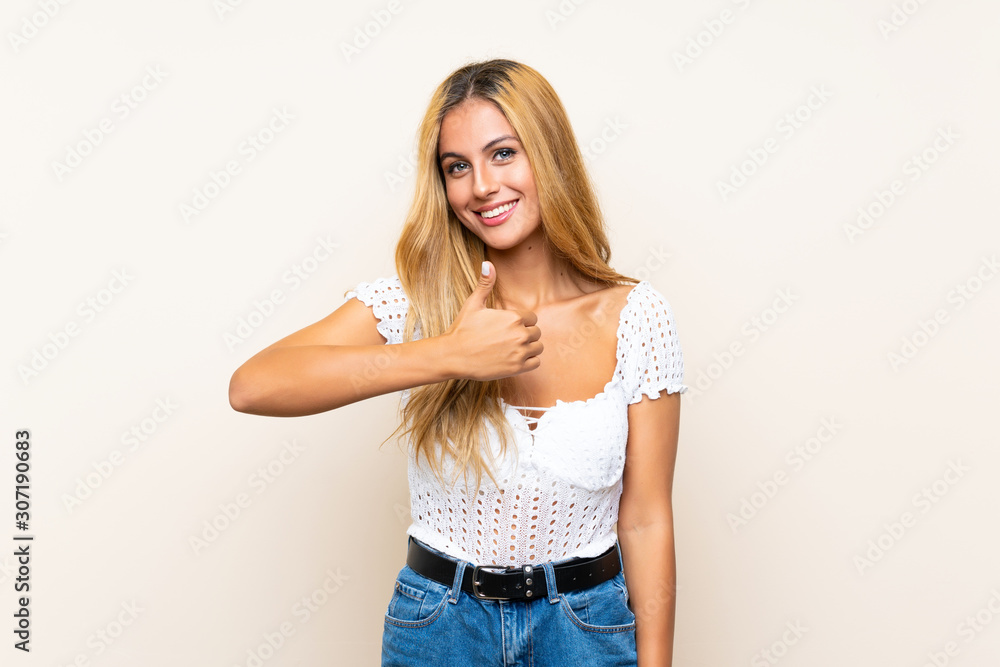 Young blonde woman over isolated background giving a thumbs up gesture Young blonde woman over isolated background giving a thumbs up gesture
