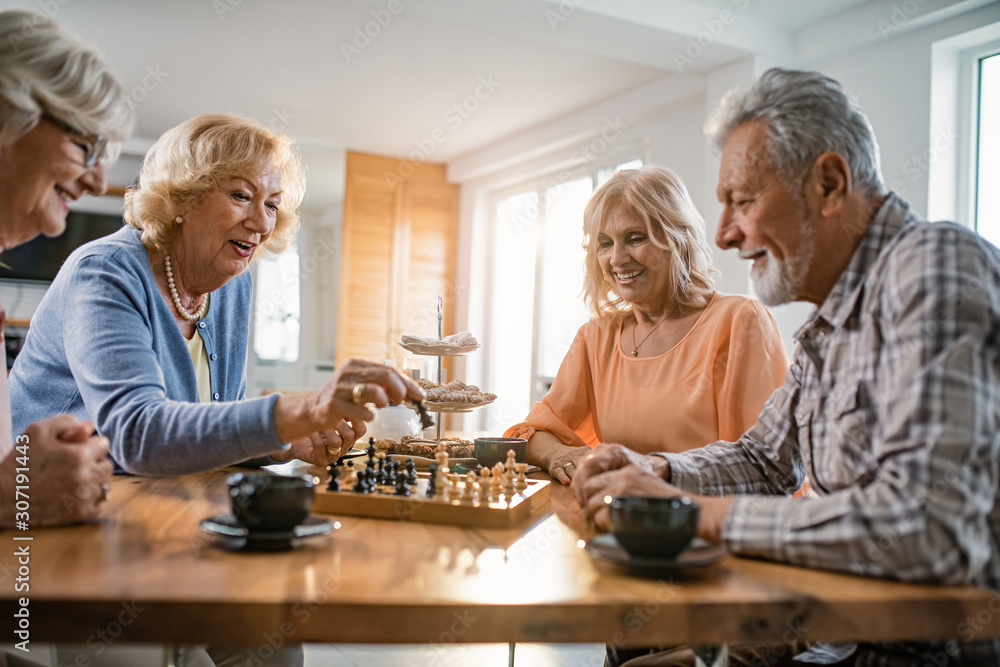 Happy mature people playing chees while enjoying in coffee time at home. Happy mature people playing chees while enjoying in coffee time at home.