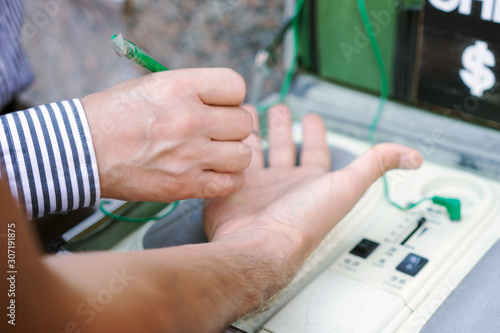 Doctor controlling the energy meridians of a young adult man hand with a reflexology technique