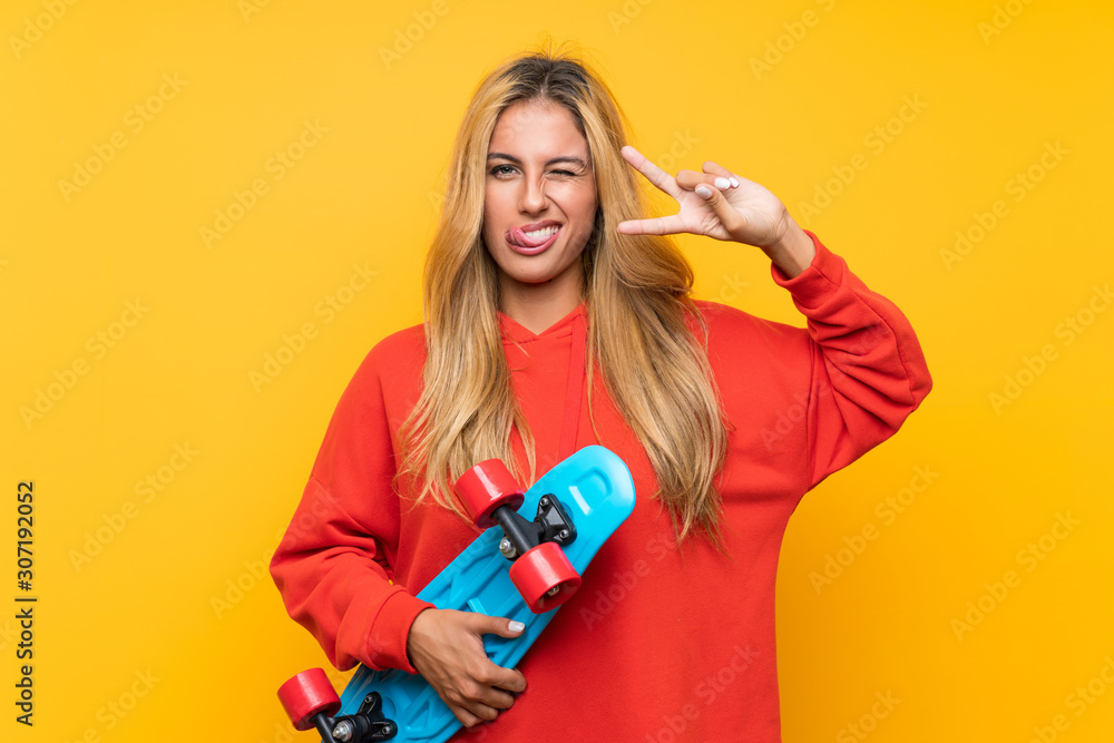 Young skater woman over isolated yellow background Young skater woman over isolated yellow background