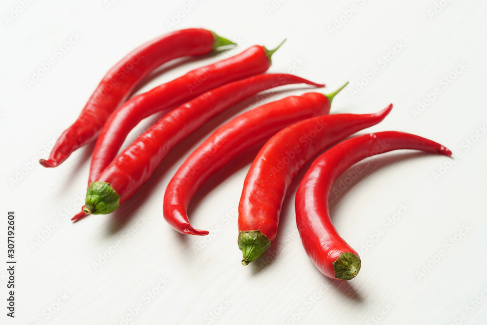 Hot peppers on a white table, side view