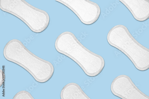 Female menstrual pads in blue background. Female hygiene and periods concept - pattern of cotton pads in isolated blue background