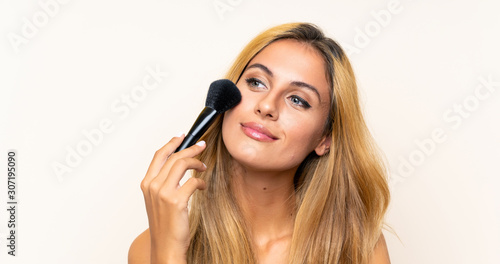 Young blonde woman with makeup brush