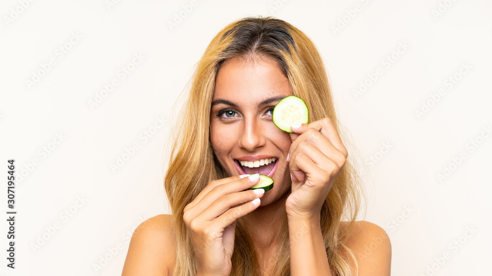 Young blonde woman holding slices of cucumber Young blonde woman holding slices of cucumber