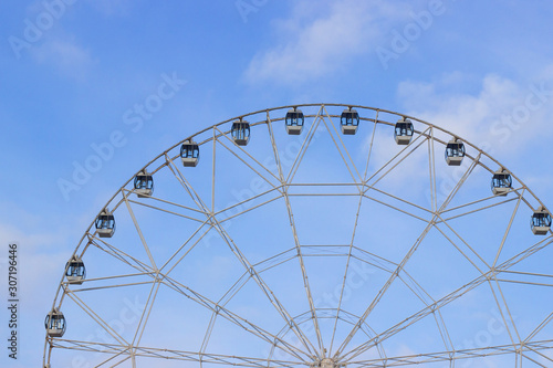 ferris wheel made of glass and metal against the blue sky.
