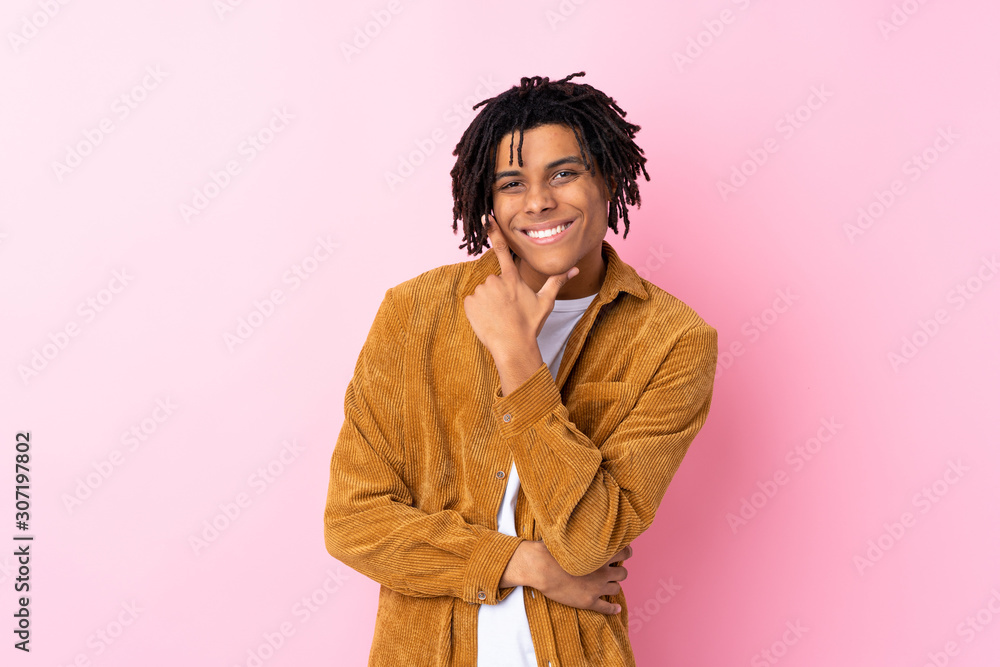 Young African American man with corduroy jacket over isolated pink background smiling Young African American man with corduroy jacket over isolated pink background smiling