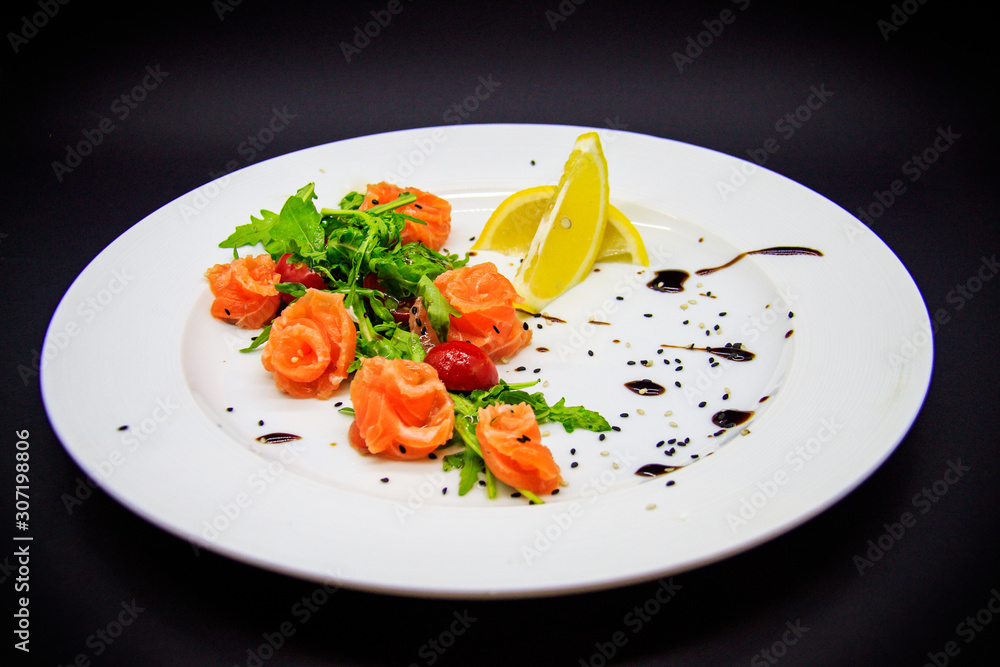 Salted salmon with garnish on black background Salted salmon with garnish on black background