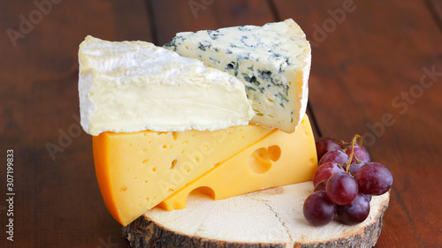 Foto Camembert, brie, hard cheese and blue cheese on wooden board