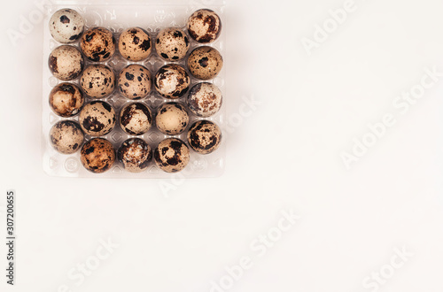  quail eggs in a box on a white background copy space