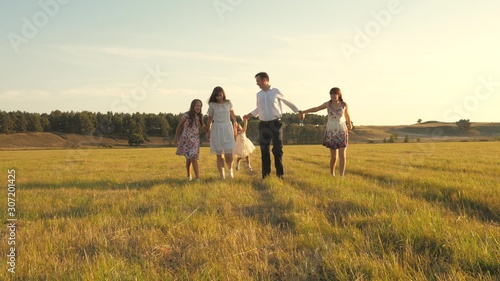 concept of a happy family. Children and mom are playing in meadow. mother and little daughter with sisters walking in park. Happy young family with child walking on summer field. happy family concept