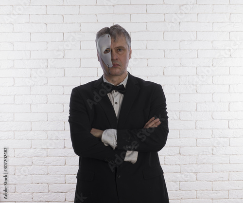 studio portrait of a businessman in a two-faced mask