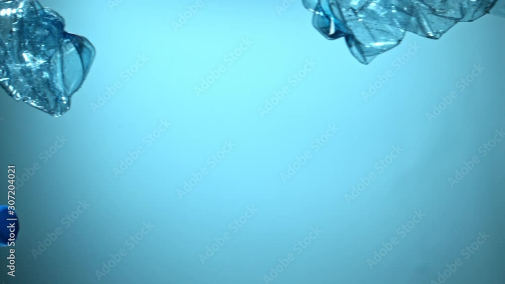 Super Slow Motion Shot of Flying Empty Plastic Bottles on Blue Gradient Background at 1000fps. Filmed with High Speed Cinema Camera at 4K Super Slow Motion Shot of Flying Empty Plastic Bottles on Blue Gradient Background at 1000fps. Filmed with High Speed Cinema Camera at 4K