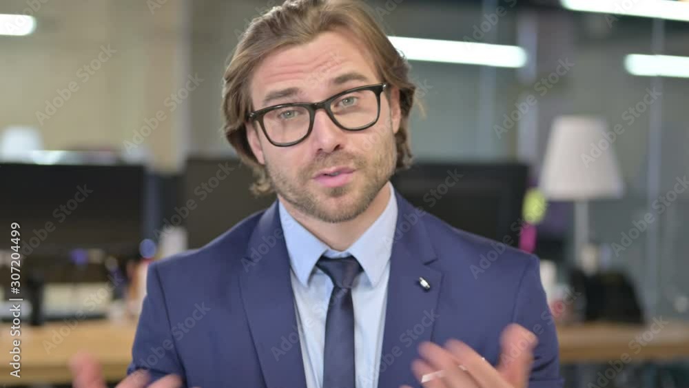 Online Video Chat by Businessman Talking in Office Online Video Chat by Businessman Talking in Office