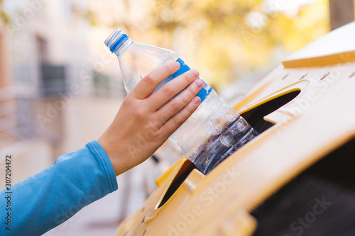 Stock photo of a woman's hand recycling a plastic bottle photo