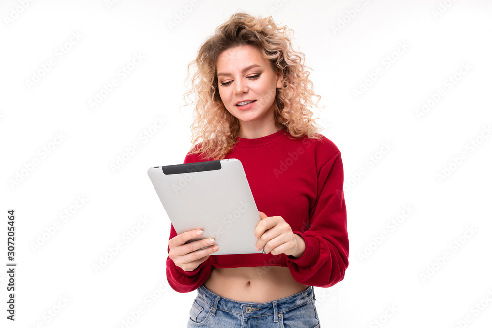European girl reads messages on a tablet on a white background European girl reads messages on a tablet on a white background