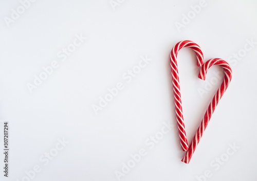 Valentines day card with candy cane sweet red heart on white background. Flat lay, top view, copy space.