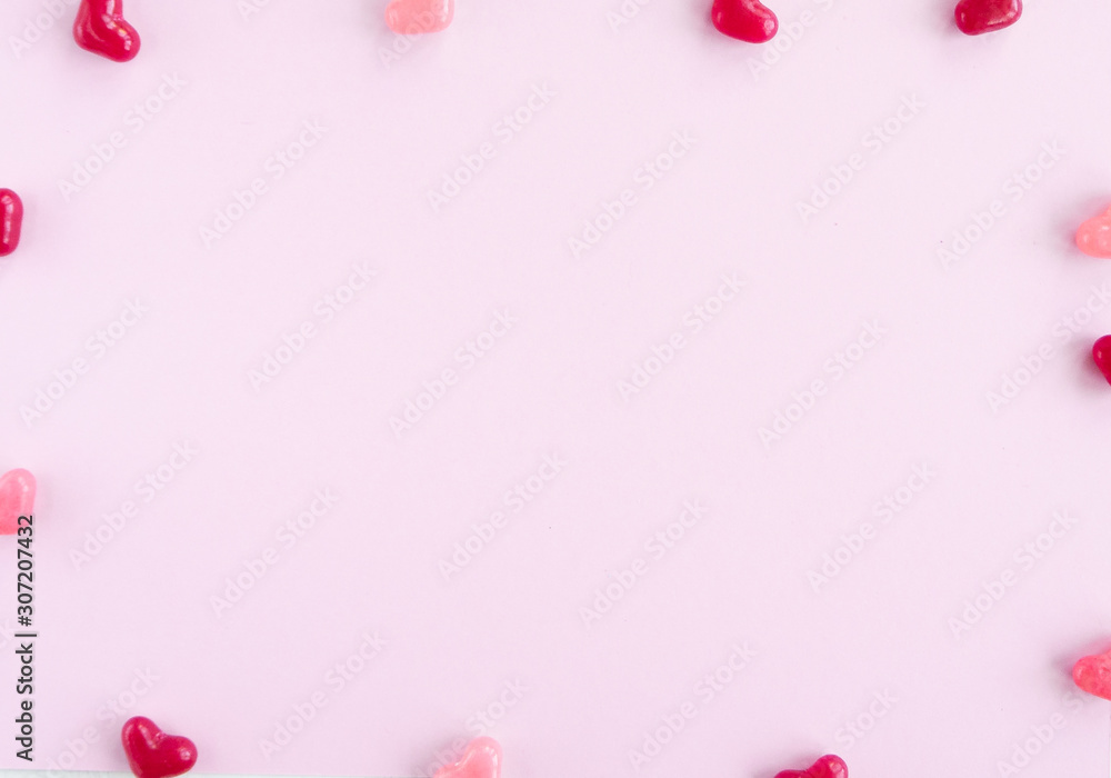 Valentines day card with tiny candy sweet hearts on pink  background. Flat lay, top view, copy space. 
