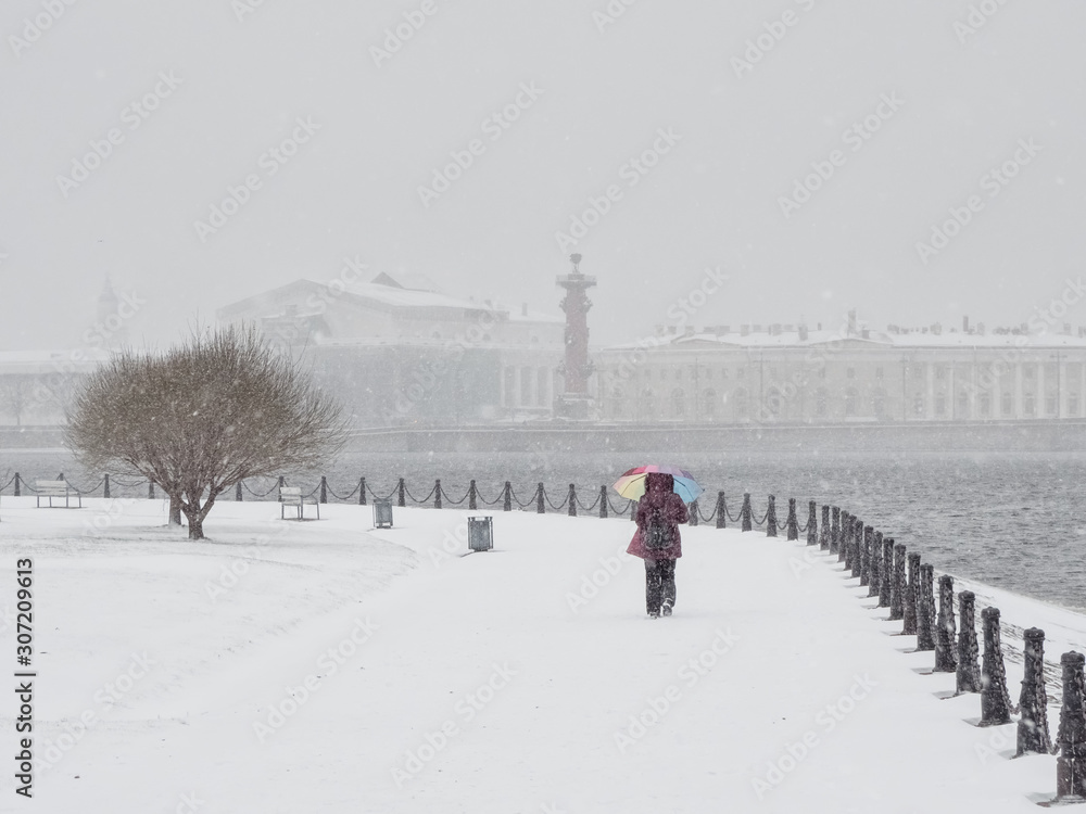 Woman with umbrella under snowfall. St. Petersburg.