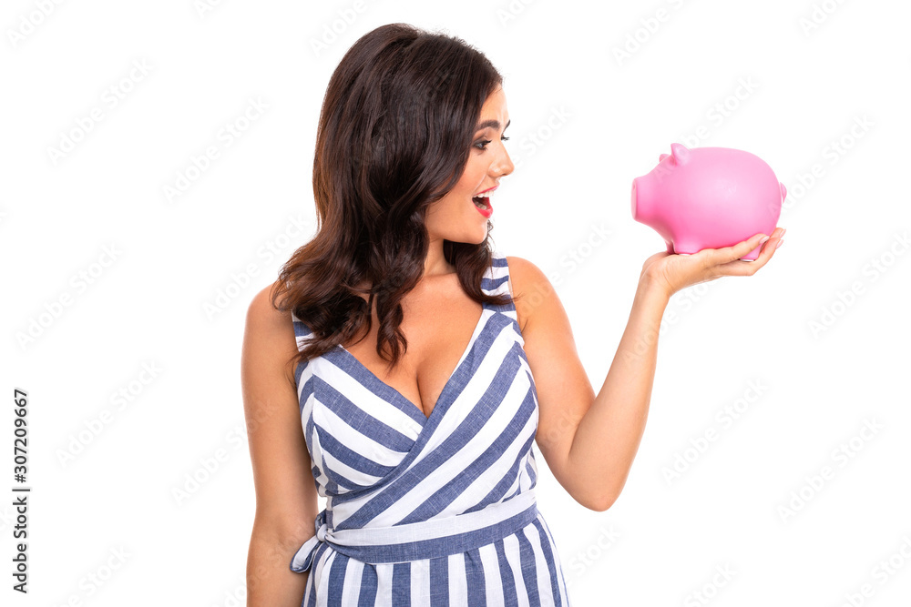 European attractive girl in dress holds a piggy bank in hands on a white studio wall, European attractive girl in dress holds a piggy bank in hands on a white studio wall,
