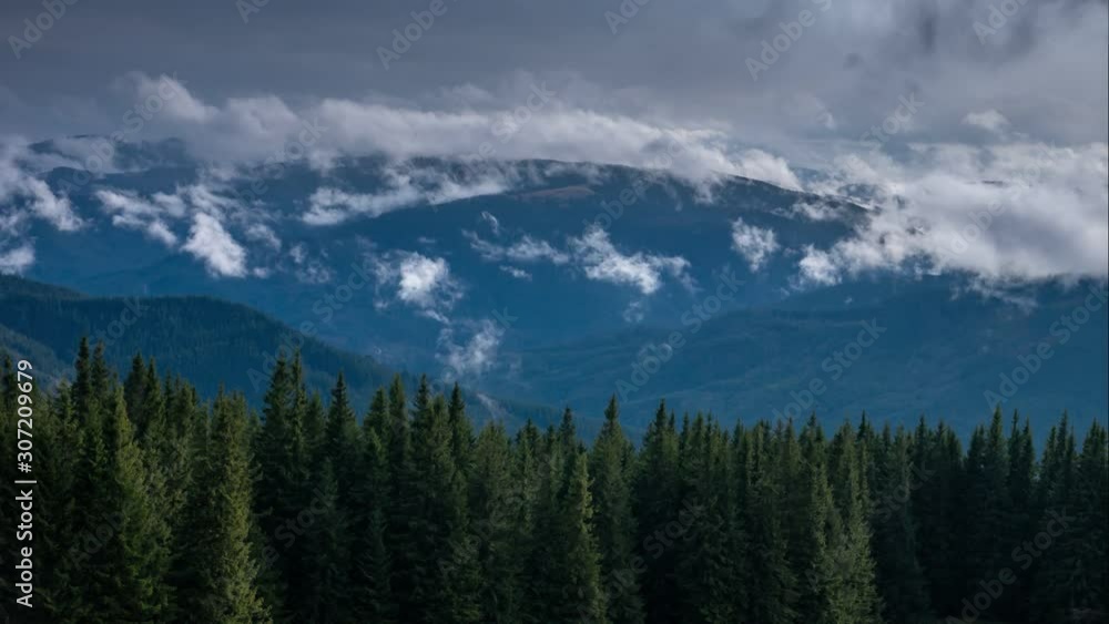 Time lapse clouds moving over pine tree highland forest. Foggy morning landscape at Carpathian mountains. Ukraine destinations and nature Time lapse clouds moving over pine tree highland forest. Foggy morning landscape at Carpathian mountains. Ukraine destinations and nature