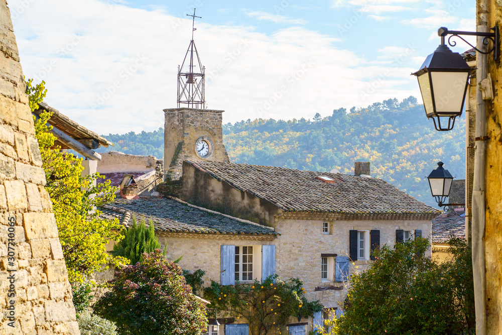 Vue sur les façades, les toits des maisons, tour d'horloge du village d'Ansuis, Luberon, Provence, France.