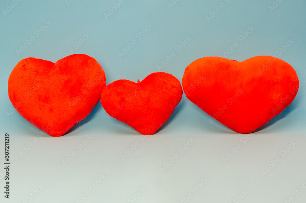 Three red hearts on a blue background. Concept of Valentine's day, holiday