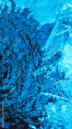 Blue ice and blue bubbling water. A variety of ice patterns and shades of blue in glacial ice and water.Background image for spa salon. Flat lay .Copy-Space