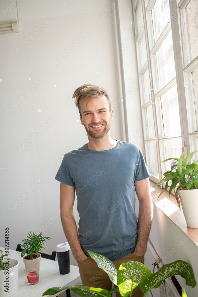 Portrait of smiling man standing at the window in office Portrait of smiling man standing at the window in office