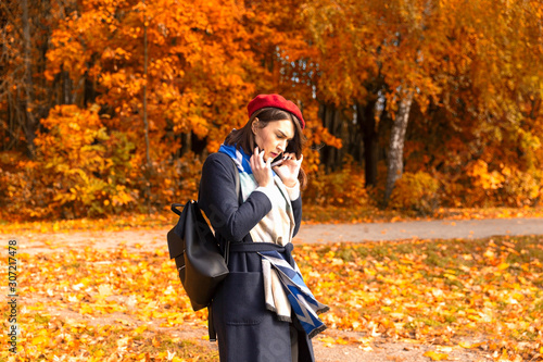 Woman talking by cellphone in the autumn park photo