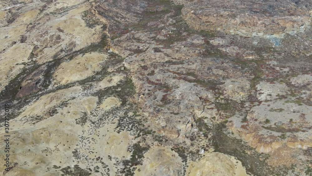 Slow drone aerial view of Akulleq island, Greenland, showing dry and desertic land with a very high detailed view of rocks and natural material from this virgin and remote island Slow drone aerial view of Akulleq island, Greenland, showing dry and desertic land with a very high detailed view of rocks and natural material from this virgin and remote island