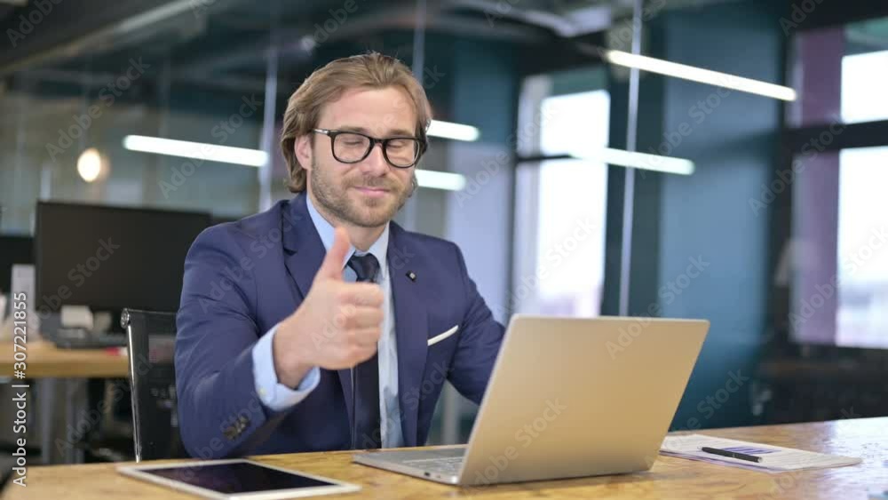 Cheerful Businessman showing Thumbs Up at Work Cheerful Businessman showing Thumbs Up at Work