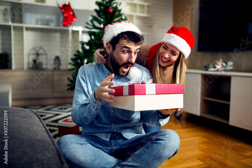 Young love couple exchanging Christmas gifts