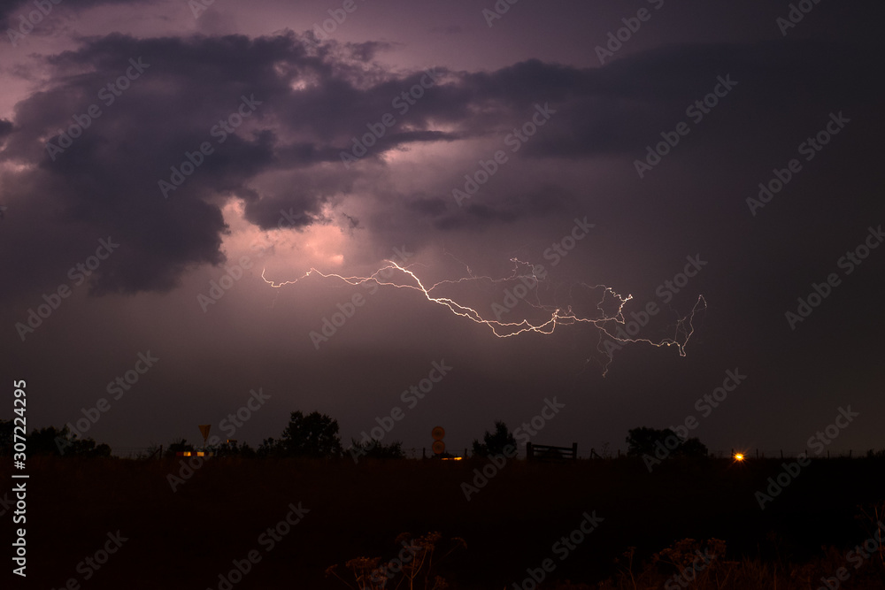 Dramatic nature scene with lightning bolt splitting through the night sky